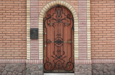 Photo of Building entrance with ornate arched wooden door