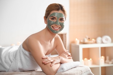 Photo of Beautiful woman with mask on face relaxing in spa salon. Space for text