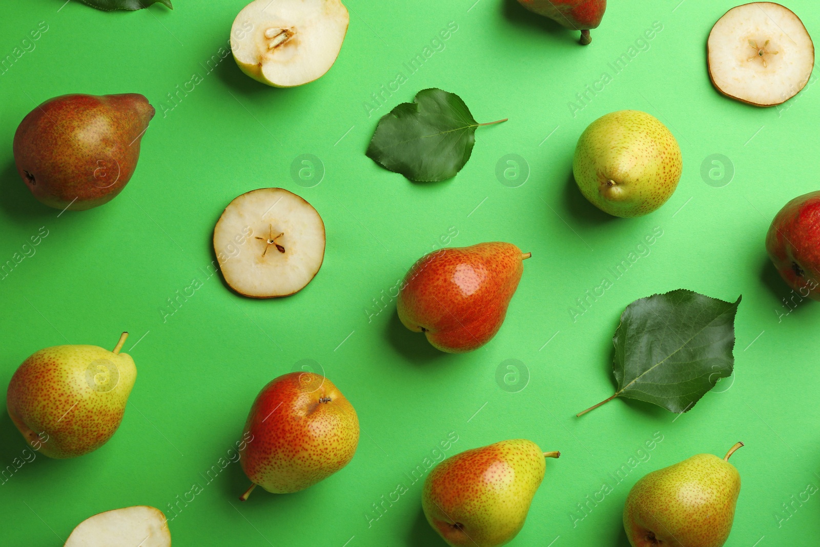 Photo of Ripe juicy pears on green background, flat lay