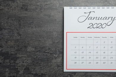 Photo of January 2020 calendar on grey stone background, top view. Space for text