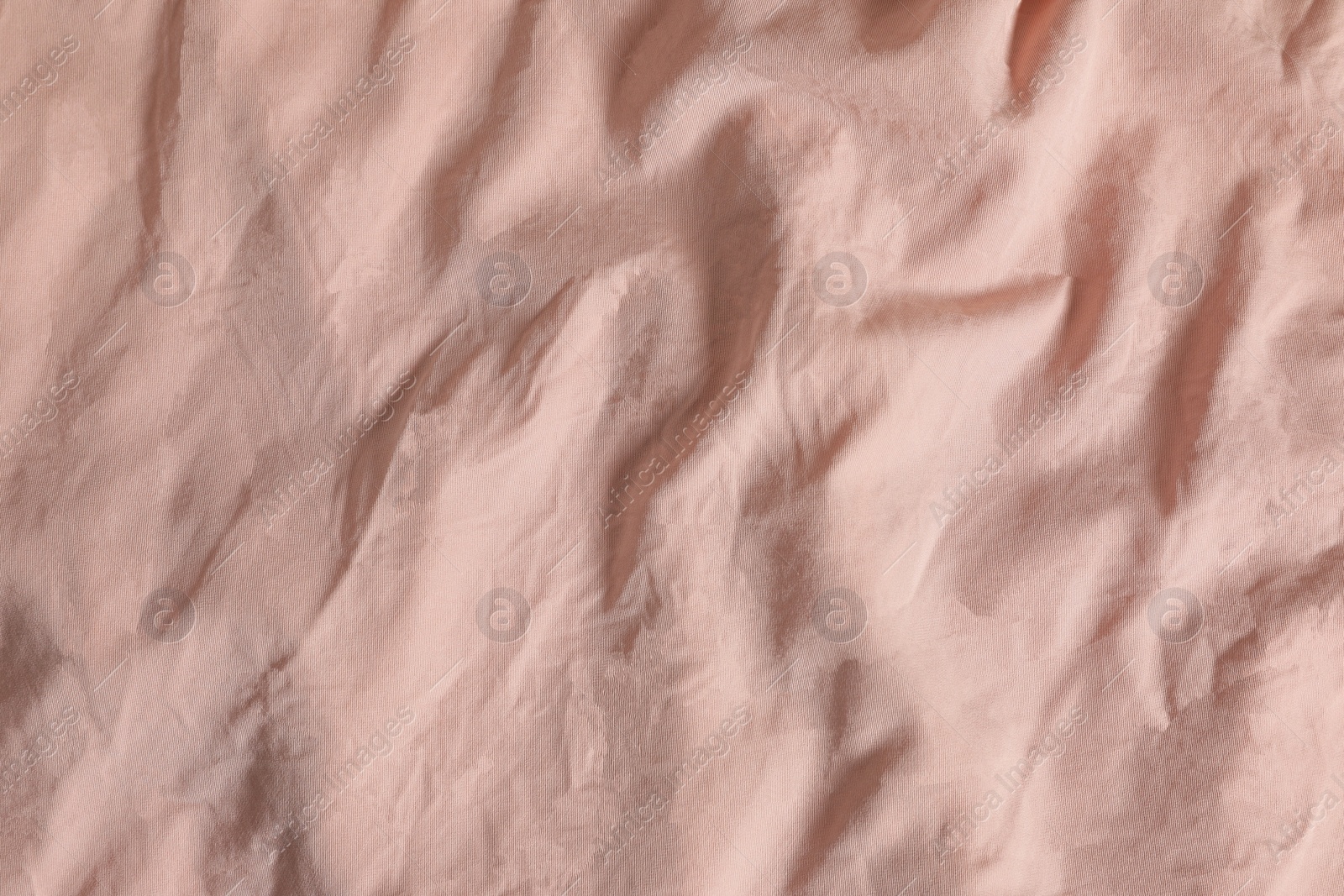 Photo of Crumpled pink fabric as background, top view