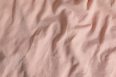 Photo of Crumpled pink fabric as background, top view