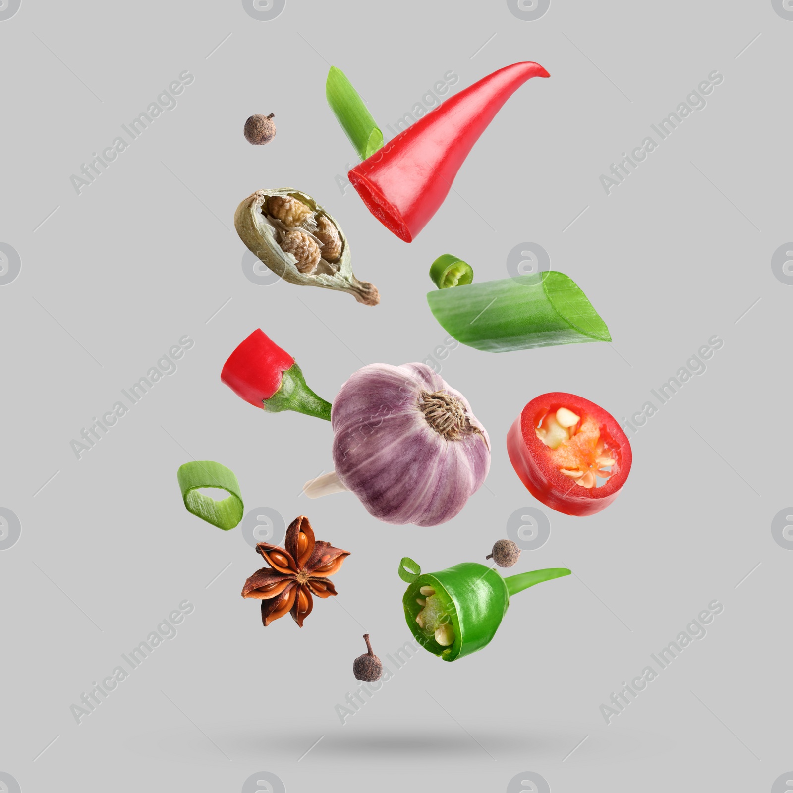 Image of Different spices falling on light grey background