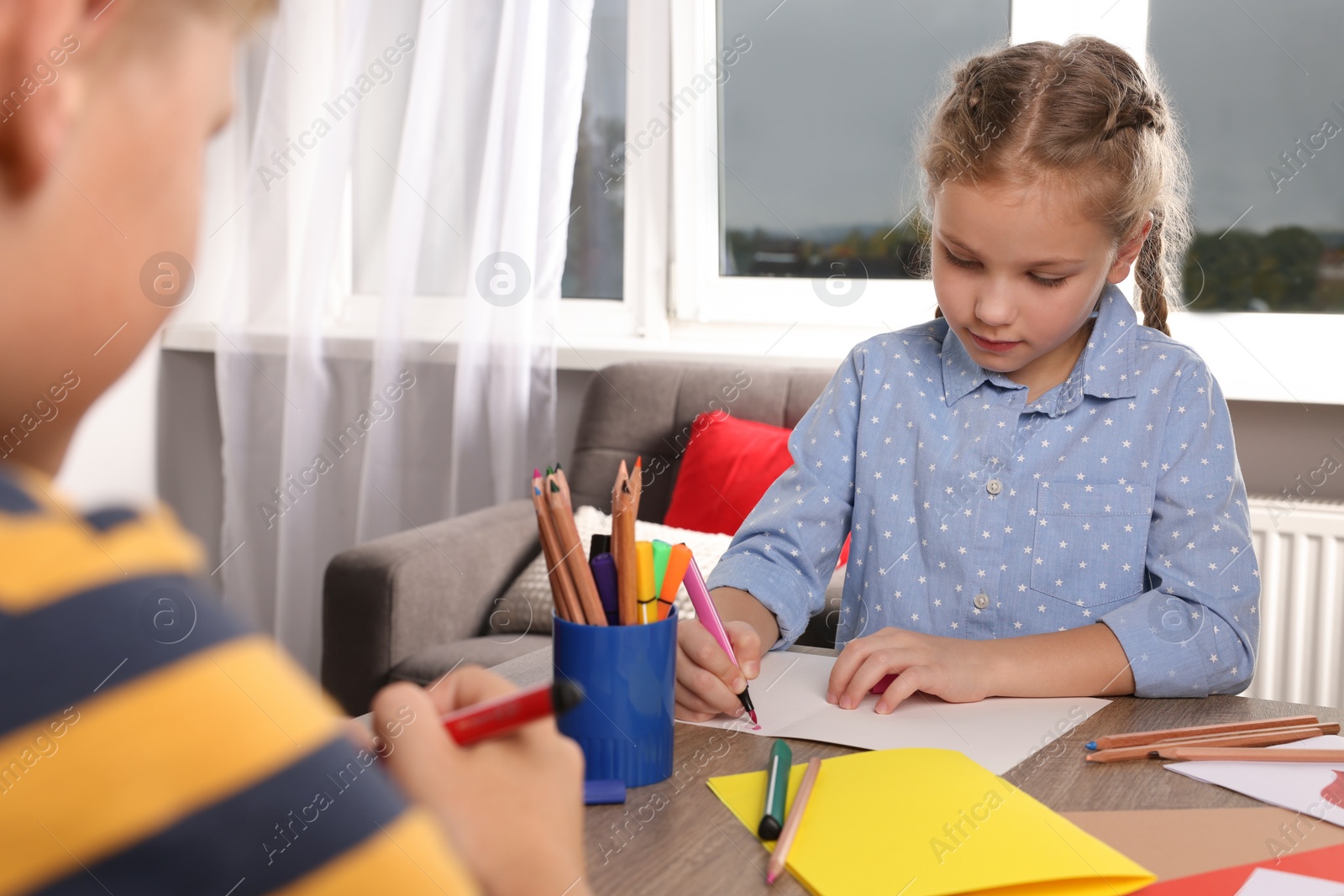 Photo of Children making beautiful greeting cards at table indoors