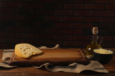Photo of Cheese and oil on wooden table. Space for text