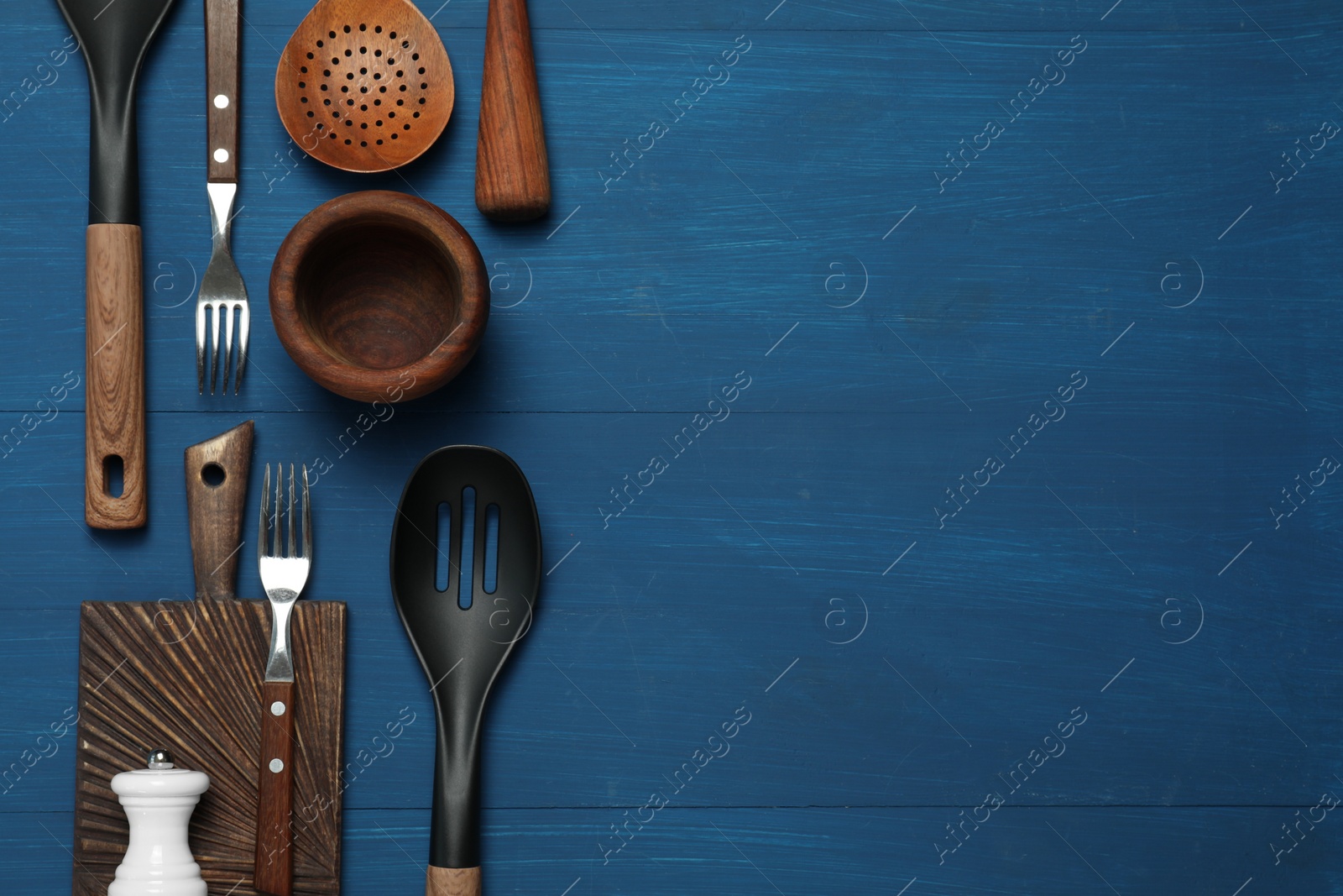 Photo of Set of different kitchen utensils on blue wooden table, flat lay. Space for text