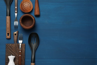 Photo of Set of different kitchen utensils on blue wooden table, flat lay. Space for text