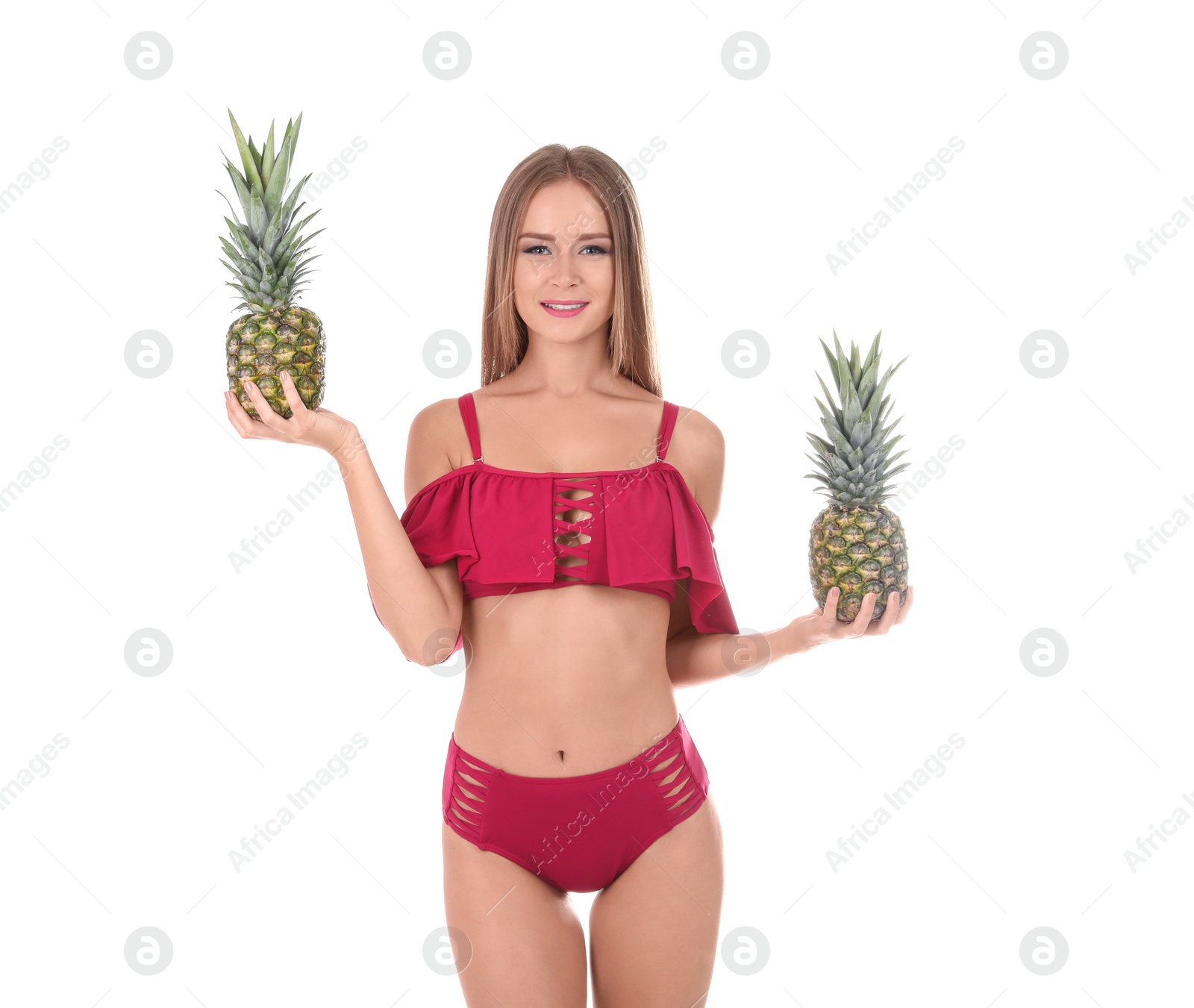 Photo of Sexy young woman in bikini with pineapples on white background