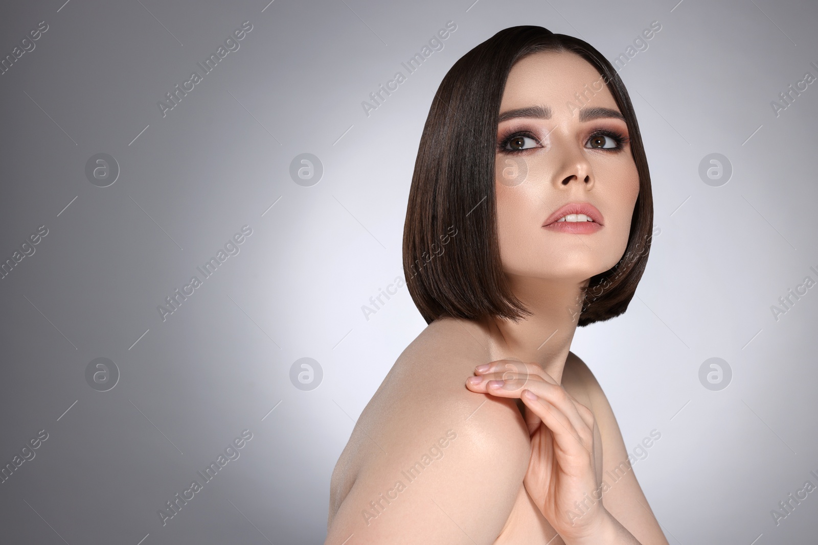 Image of Portrait of pretty young woman with brown hair on grey background, space for text