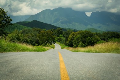 Photo of Picturesque view of empty road near trees and mountains