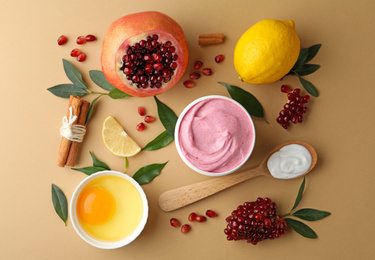 Flat lay composition with natural homemade mask, pomegranate and ingredients on beige background