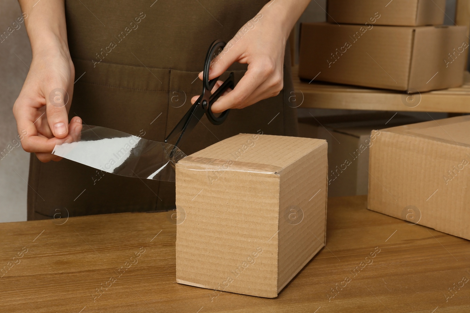 Photo of Woman packing box at table, closeup. Space for design