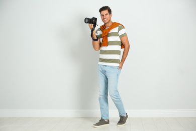 Professional photographer working near white wall in studio