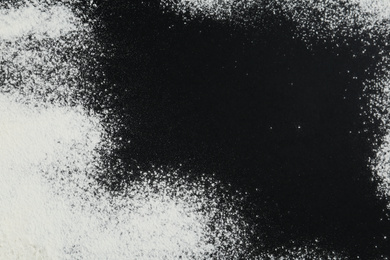 Photo of Flour on black table, top view. Space for text