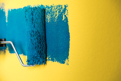 Photo of Painting yellow wall with blue dye, closeup view