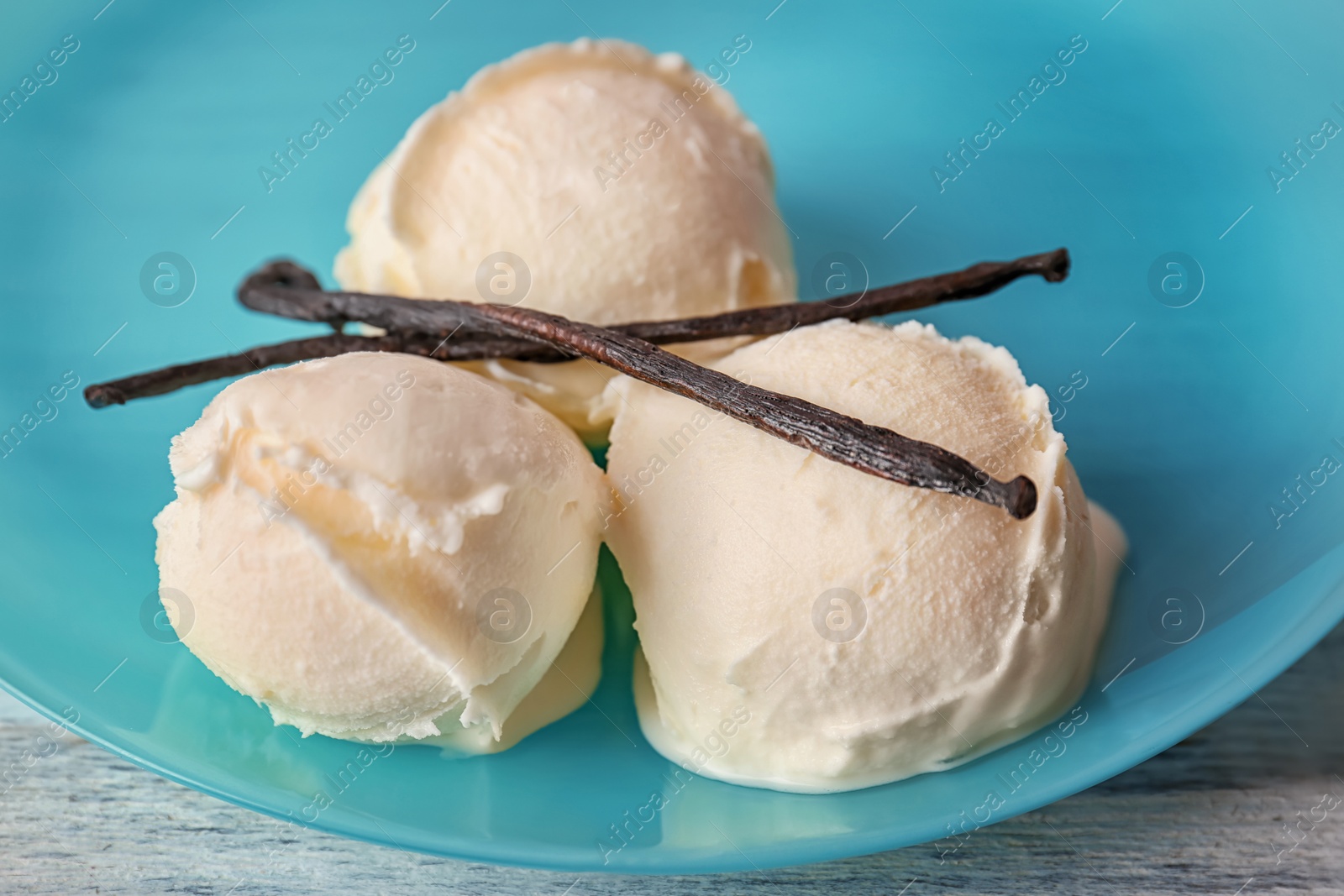 Photo of Plate with tasty vanilla ice cream on table, closeup