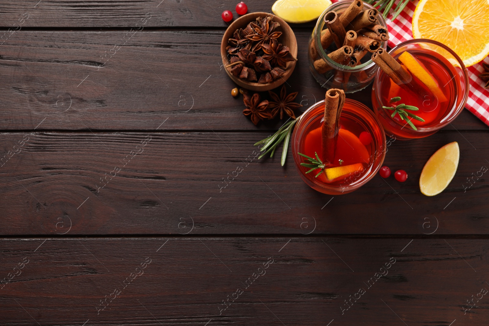 Photo of Aromatic punch drink and ingredients on wooden table, flat lay. Space for text