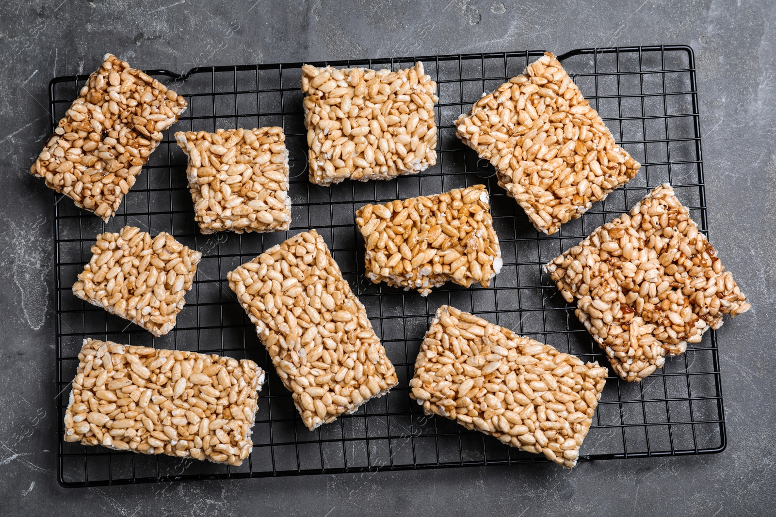 Photo of Delicious rice crispy treats on grey table, flat lay