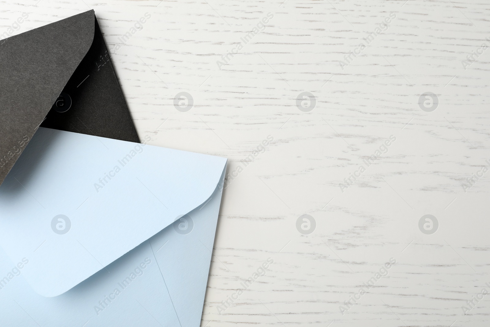 Photo of Paper envelopes on white wooden background, flat lay. Space for text