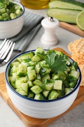 Photo of Bowl of delicious cucumber salad served on light table