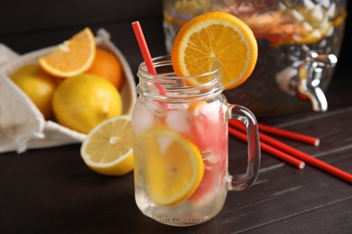 Delicious refreshing lemonade with orange slices in mason jar on wooden table