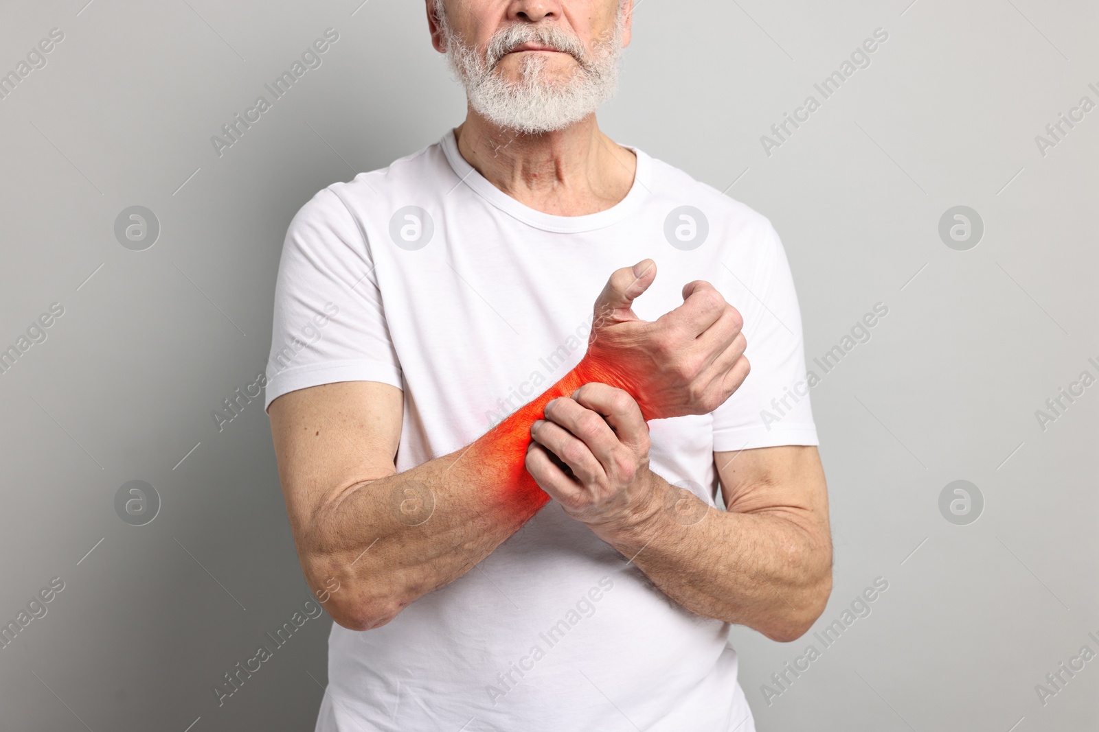 Image of Arthritis symptoms. Man suffering from pain in his wrist on grey background, closeup