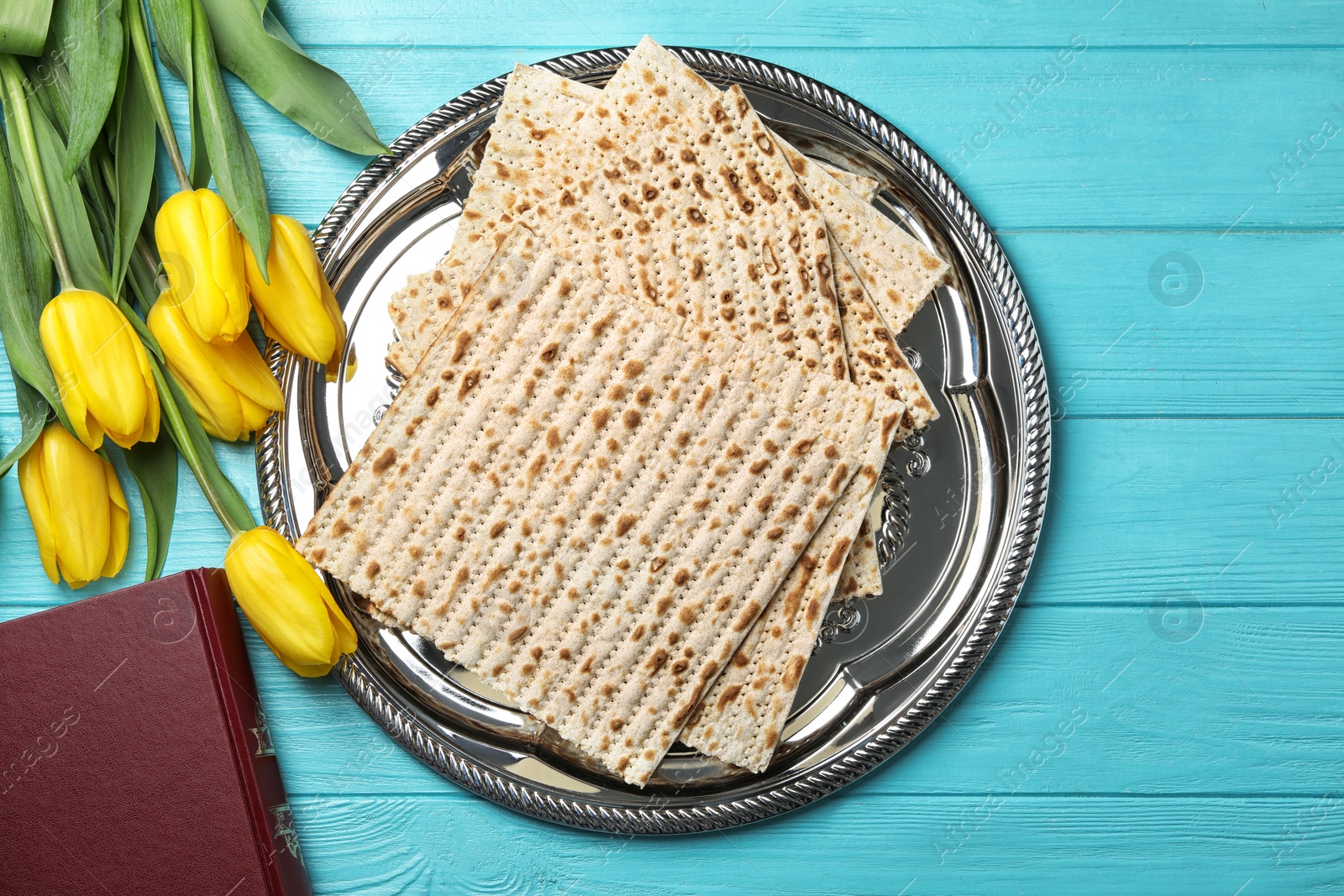 Photo of Flat lay composition of matzo, Torah and flowers on wooden background. Passover (Pesach) Seder