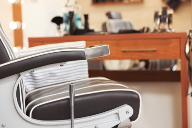 Photo of Closeup view of professional barber chair in hairdressing salon