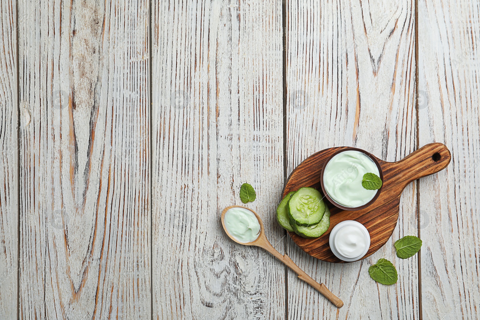 Photo of Composition with body cream in jars on wooden background, top view