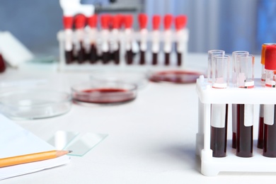Photo of Test tubes with blood samples for analysis on table in laboratory. Space for text