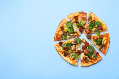 Photo of Delicious vegetarian pizza with mushrooms, vegetables and parsley on light blue background, top view. Space for text