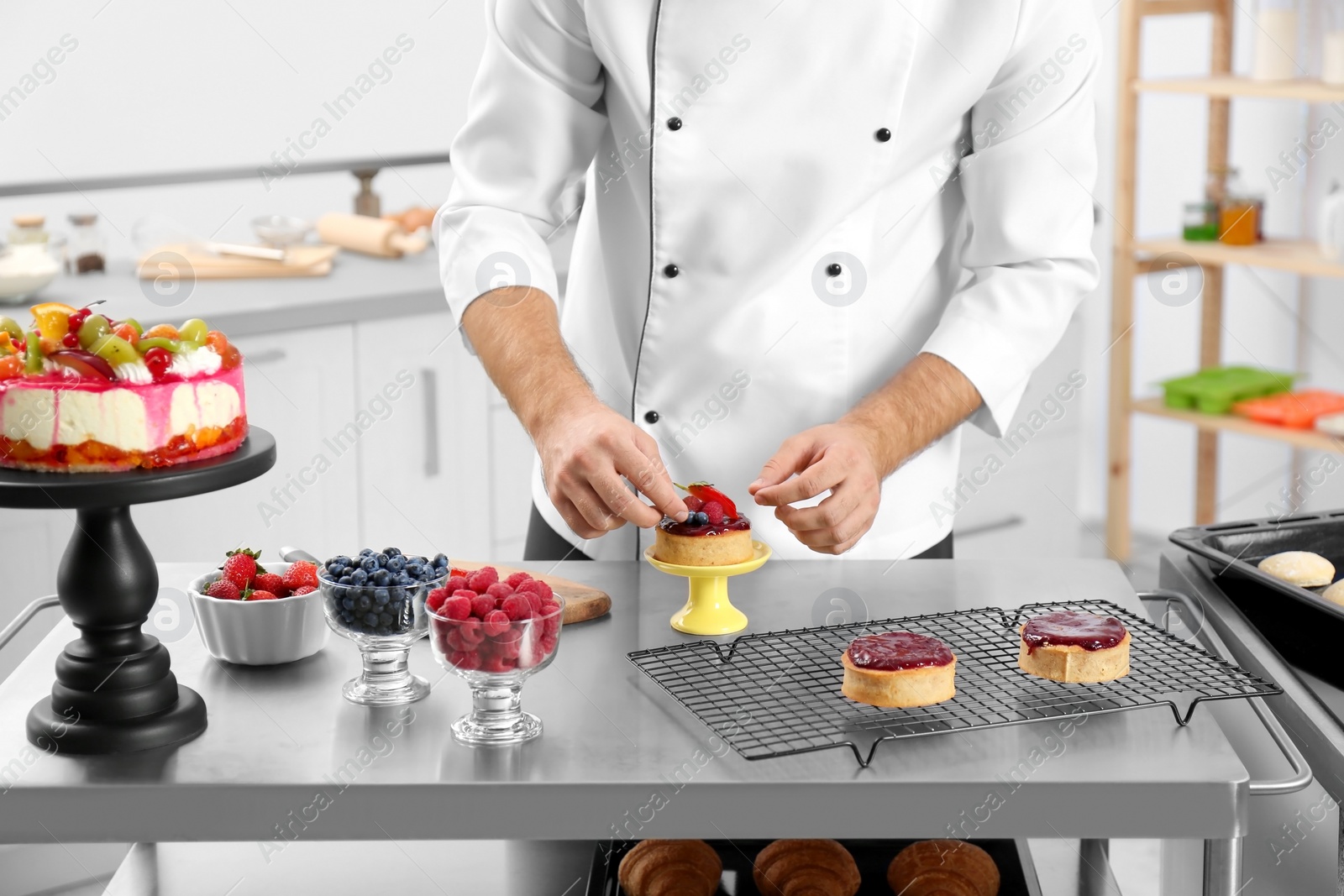 Photo of Male pastry chef preparing dessert at table in kitchen, closeup