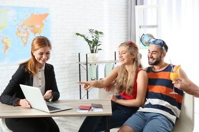 Beautiful young couple visiting travel agency office