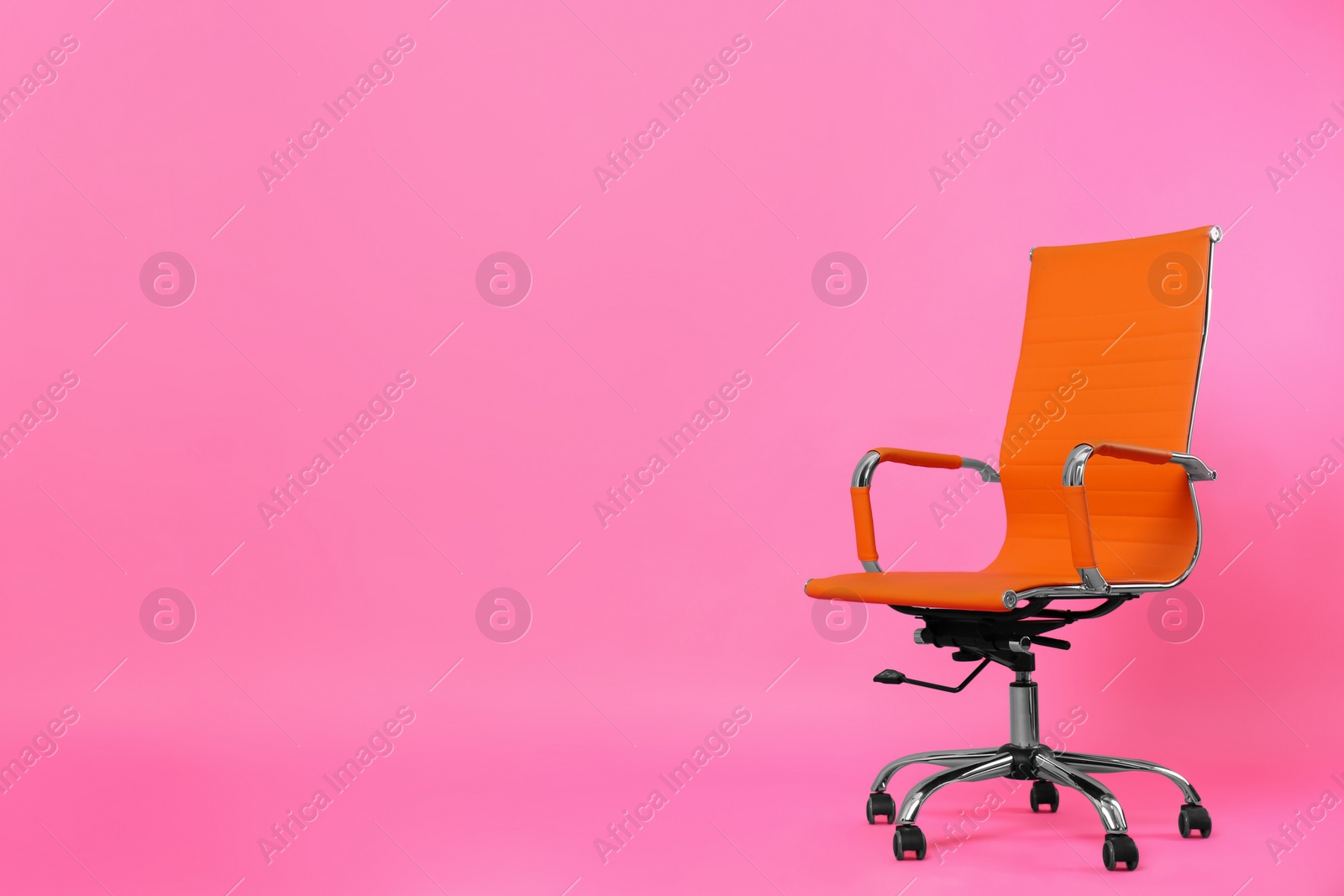 Photo of Comfortable office chair on pink background, space for text