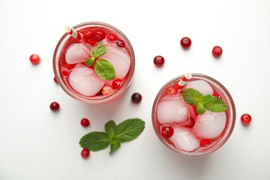 Tasty refreshing cranberry cocktail with mint on white table, flat lay