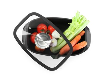 Photo of Fresh products in black pot and lid isolated on white, top view