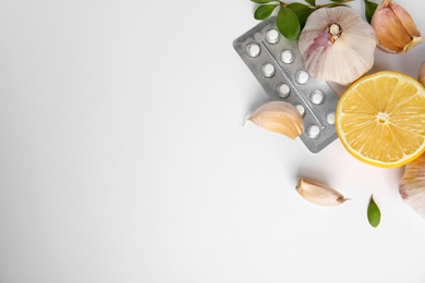 Composition with garlic and other cold remedies on white background, top view