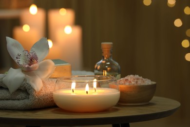 Composition with different spa products and orchid flower on wooden table