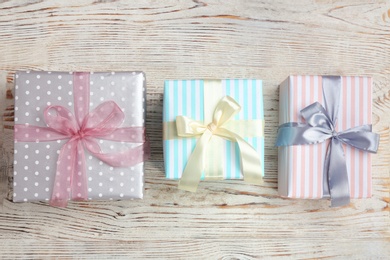 Photo of Beautifully decorated gift boxes on wooden background, top view
