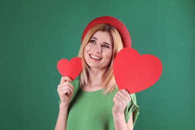 Photo of Beautiful woman with paper hearts on color background