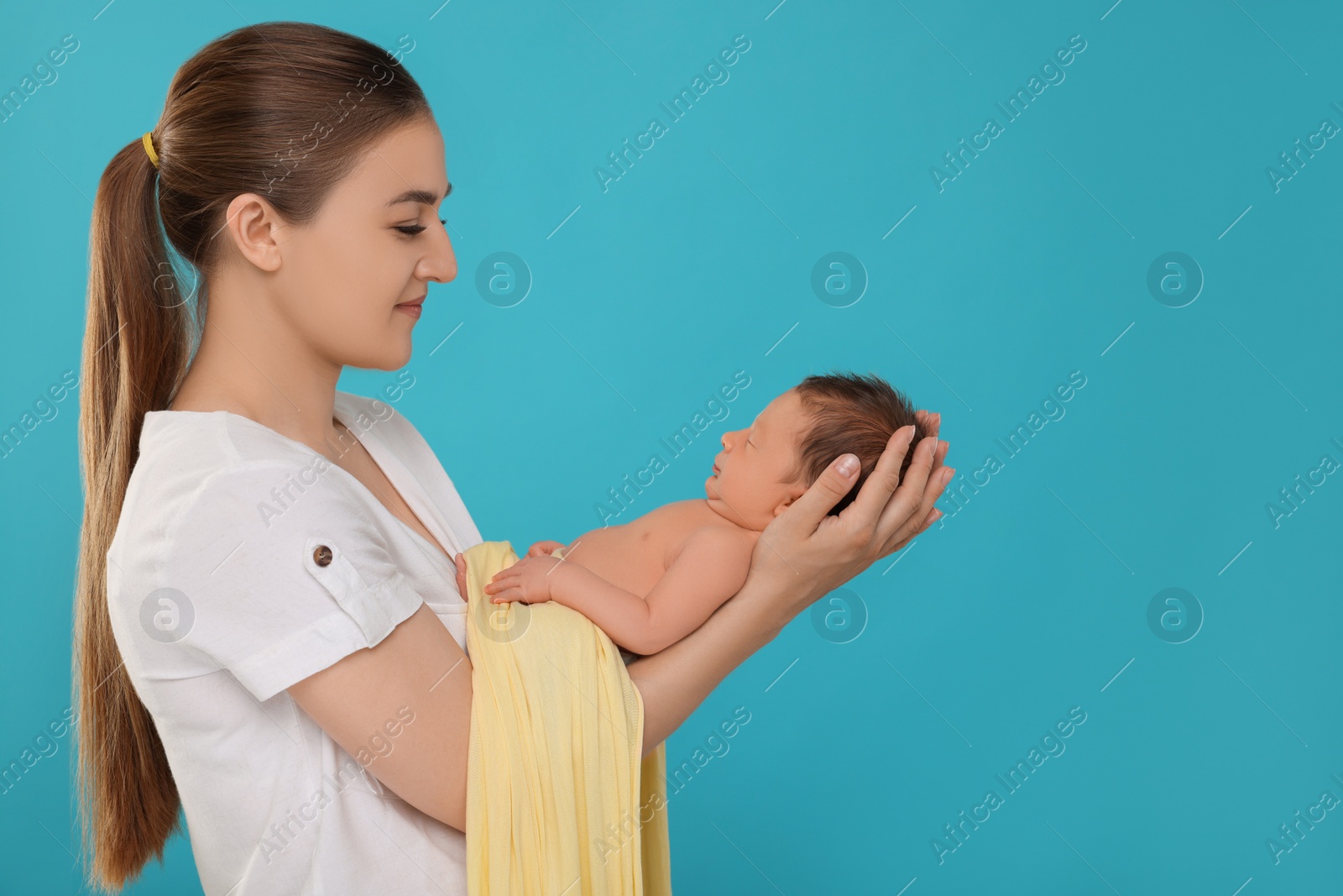 Photo of Mother with her cute newborn baby on light blue background. Space for text