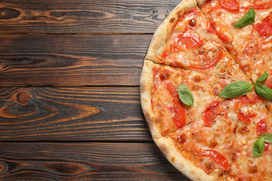 Delicious pizza Margherita on wooden table, top view. Space for text