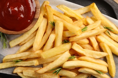 Delicious french fries served with ketchup on board, flat lay