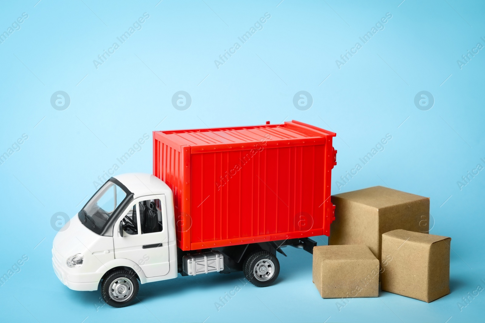 Photo of Toy truck with boxes on blue background, space for text. Logistics and wholesale concept