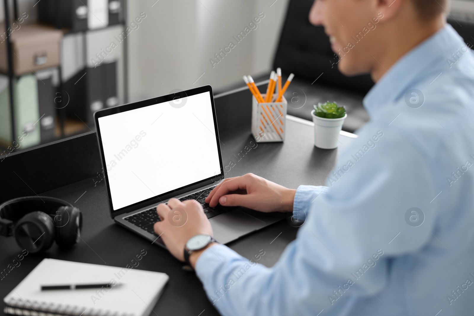 Photo of Man watching webinar at table in office, closeup