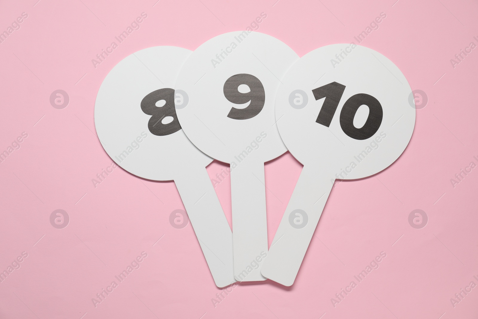 Photo of Auction paddles with numbers on pink background, top view