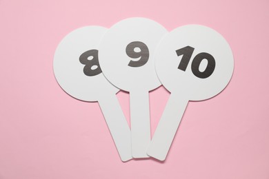 Photo of Auction paddles with numbers on pink background, top view