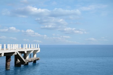 Beautiful white pier in sea on sunny day, space for text