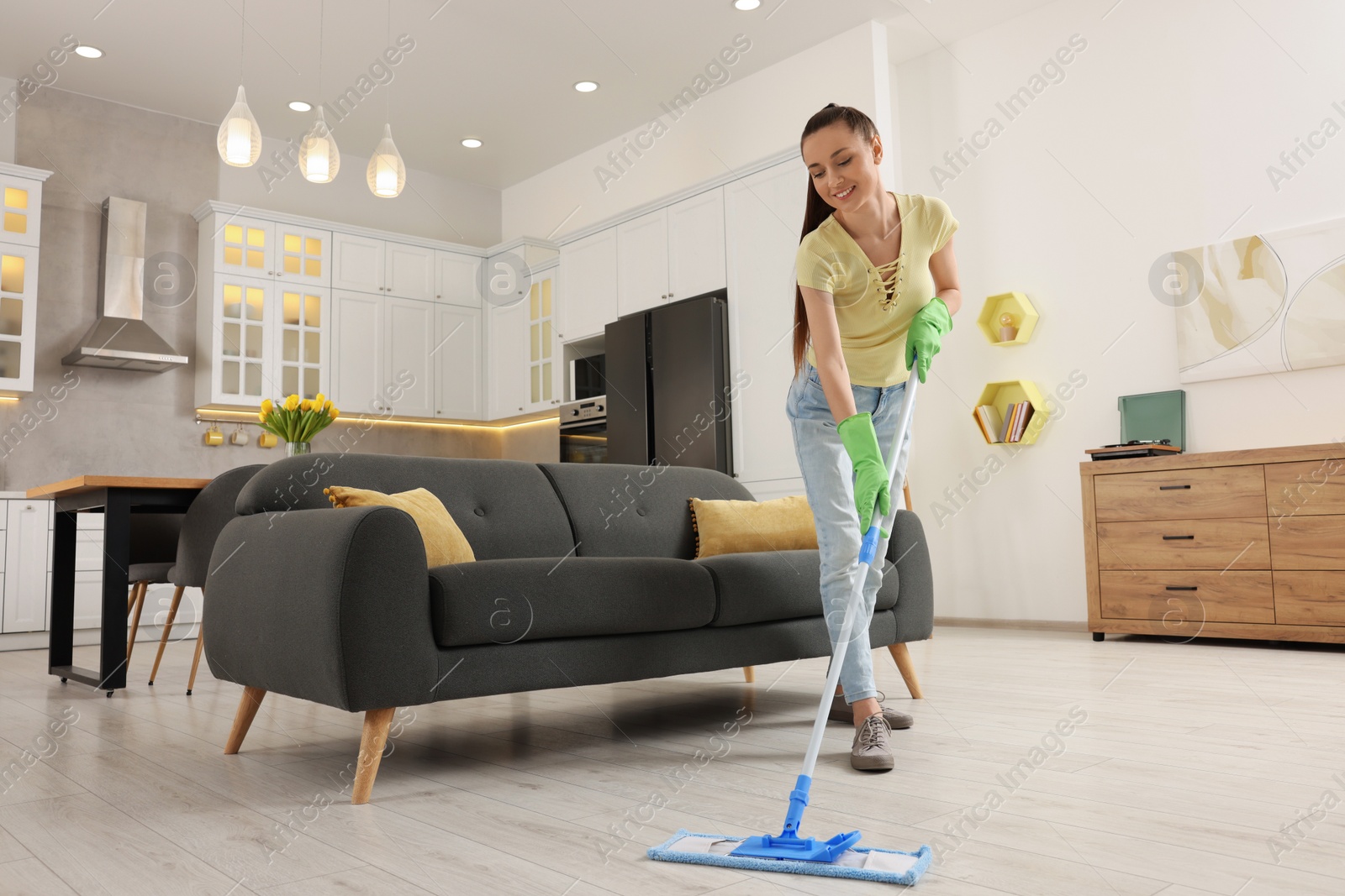 Photo of Spring cleaning. Young woman with mop washing floor at home