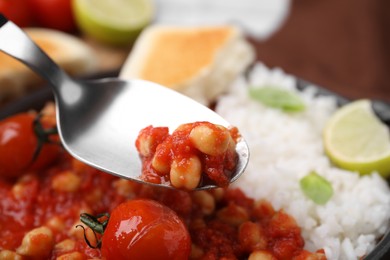 Photo of Spoon with delicious chickpea curry, closeup view